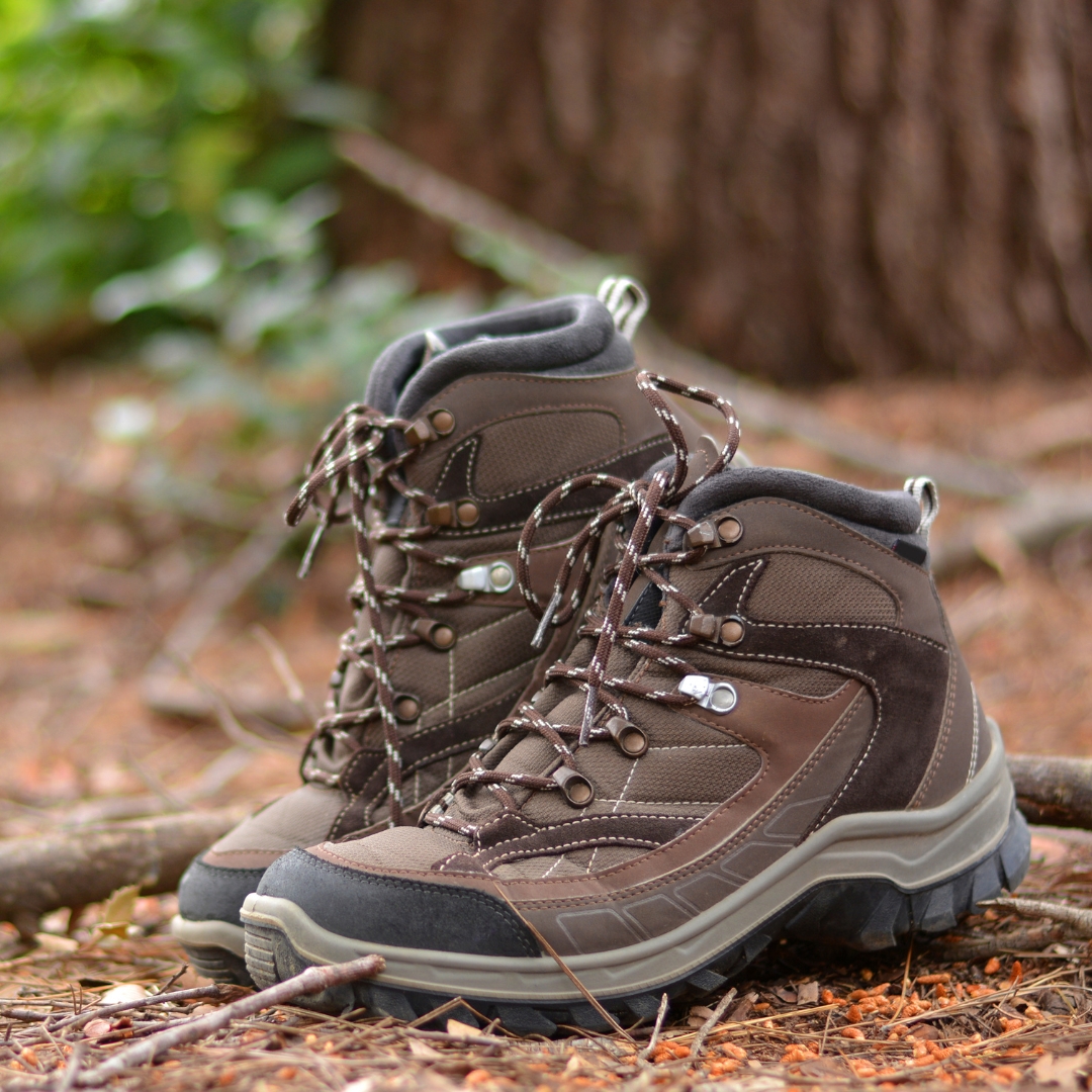 A pair of brown hiking boots on a trail.